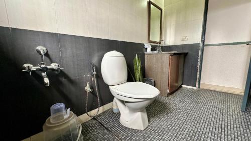 a bathroom with a toilet and a shower at Veu Munnar Retreat - Valley View Rooms in Munnar