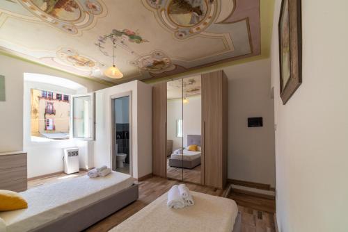 a bedroom with two beds and a ceiling at Sardinian Gallery Sa Funtana in Bosa