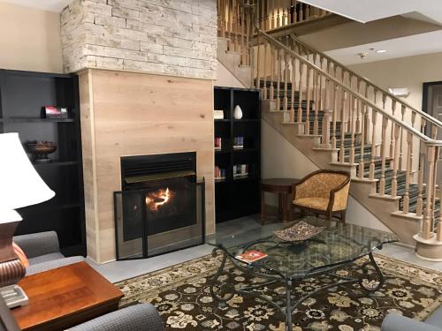 a living room with a fireplace and a staircase at Country Inn & Suites by Radisson, Dalton, GA in Dalton