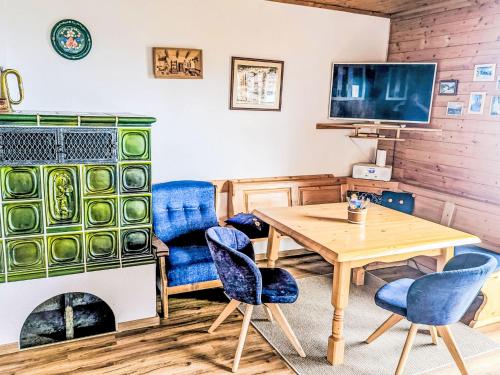 a living room with a table and chairs and a fireplace at Chalet Willegger by Interhome in Hochrindl