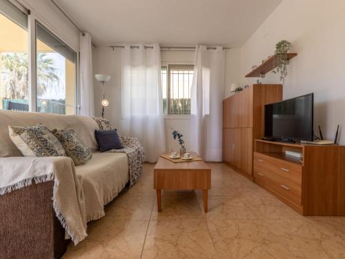 a living room with a couch and a flat screen tv at Holiday Home Flamenc 2 by Interhome in Riumar