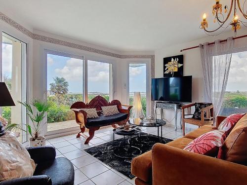 a living room with a couch and a tv at Holiday Home Ty Nevez by Interhome in Sibiril