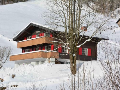 a building with red doors in the snow at Apartment Chalet Heureka-Horbis by Interhome in Engelberg