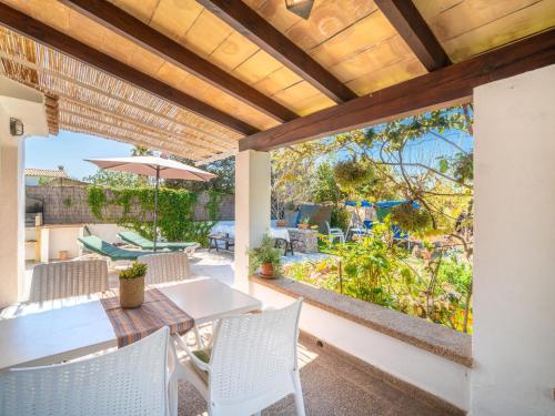 a patio with a table and chairs and an umbrella at Holiday Home Can Niu by Interhome in Pollença