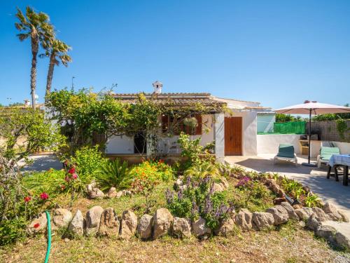 a garden with flowers in front of a house at Holiday Home Can Niu by Interhome in Pollença