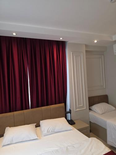 a bedroom with two beds and a red curtain at Eyüp Sultan Palace Hotel in Istanbul