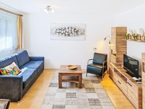 a living room with a blue couch and a tv at Apartment Christine by Interhome in Prutz