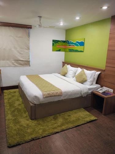 a bedroom with a large bed with a green wall at Westwood Riverside in Munnar