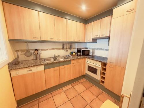 a small kitchen with wooden cabinets and a sink at Apartment Port Pals Summer Vibes by Interhome in Pals
