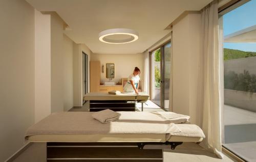 a woman in a hospital room with two beds at Mitsis Faliraki in Faliraki