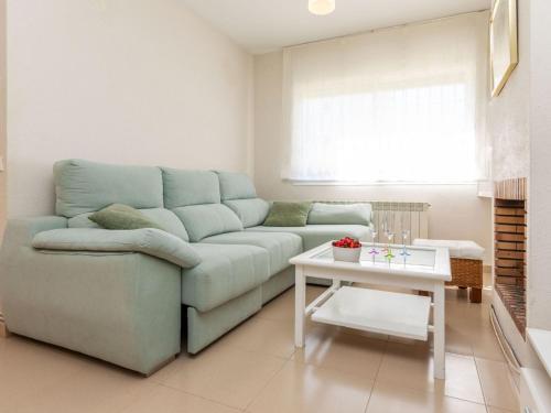 a living room with a blue couch and a table at Holiday Home Canyadell by Interhome in Torredembarra