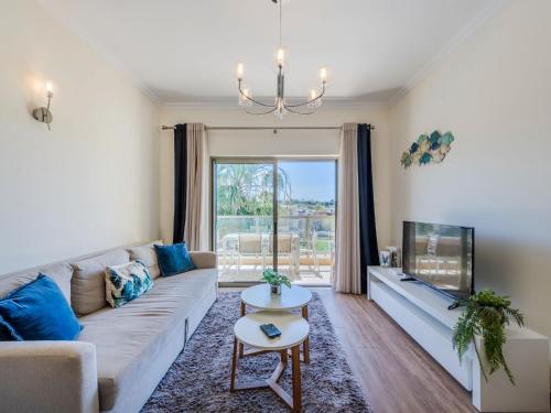 a living room with a couch and a tv at Apartment Jardins Marina T2 - VIP Properties by Interhome in Albufeira
