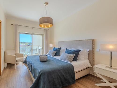 a bedroom with a large bed with a blue blanket at Apartment Jardins Marina T2 - VIP Properties by Interhome in Albufeira