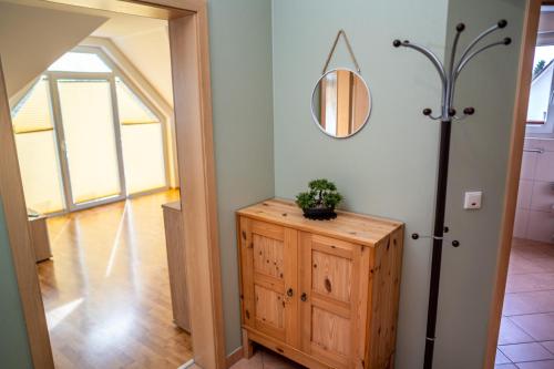 a hallway with a mirror and a wooden cabinet at Ferienwohnung Schultz in Zinnowitz