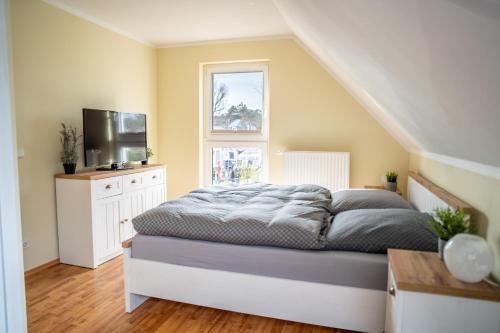 a bedroom with a bed with a television and a window at Ferienwohnung Schultz in Zinnowitz