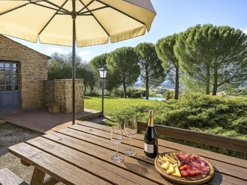 a picnic table with a bottle of wine and a bowl of fruit at Apartment Asciano by Interhome in Vergelle