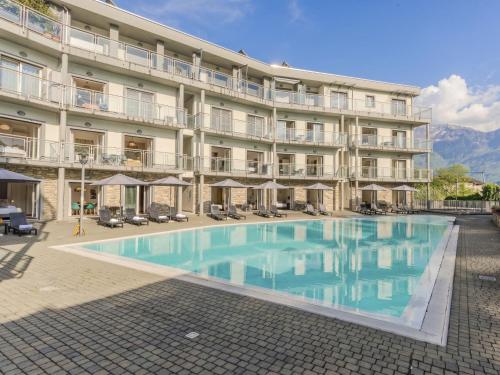 a hotel with a large swimming pool in front of a building at Apartment Nancy by Interhome in Domaso