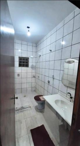 a bathroom with a tub and a toilet and a sink at Casa ampla central in Dourados