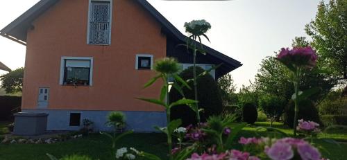 a house with flowers in front of it at Holiday Home Vuković Plitvice Mountain Retreat in Saborsko