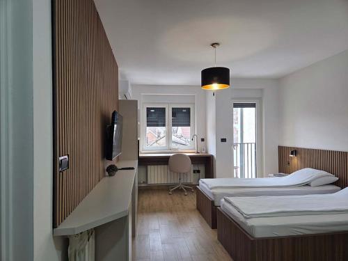 a hotel room with two beds and a television at Apartmani Optimist in Valjevo