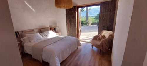 a bedroom with a bed and a chair and a window at El Limonar in Murcia
