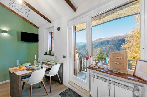 a dining room with a table and a large window at La Chicchetta - Happy Rentals in Sauze d'Oulx