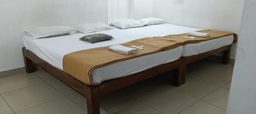 a large bed with white sheets and pillows on it at Beach Times Resort in Kottakupam
