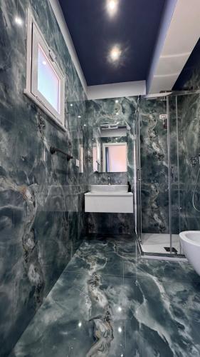 a bathroom with a sink and a mirror and a tub at BlueBay room Calabria in Vibo Valentia Marina