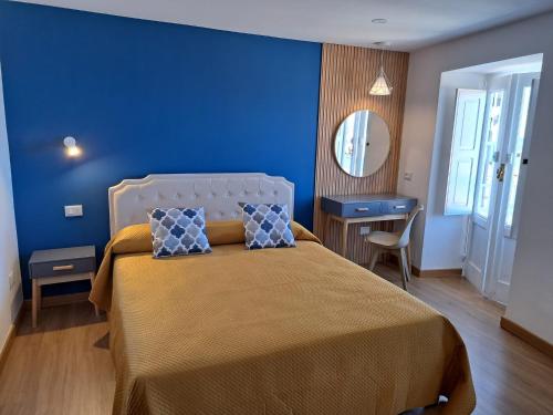 a blue bedroom with a bed and a mirror at Ondablurooms1 in Pizzo