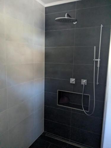 a bathroom with a shower with gray tiles at Bungalow HWW am Feldrand Ideal für Feriengäste und Handwerker in Wentorf