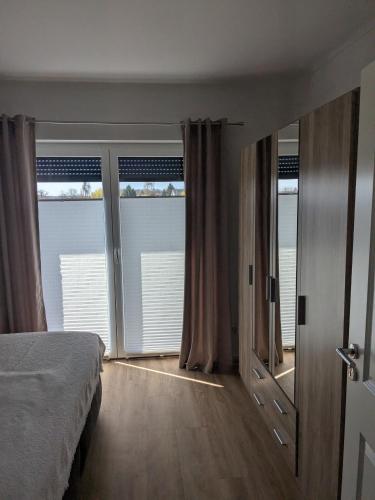a bedroom with a bed and sliding glass doors at Bungalow HWW am Feldrand Ideal für Feriengäste und Handwerker in Wentorf