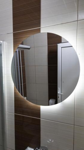 a bathroom with a circular mirror on a wall at Hotel Kicevo in Kičevo
