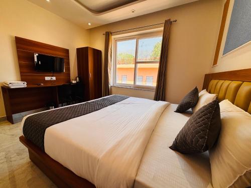 a bedroom with a large bed and a window at Hotel shivay palace in Rishīkesh