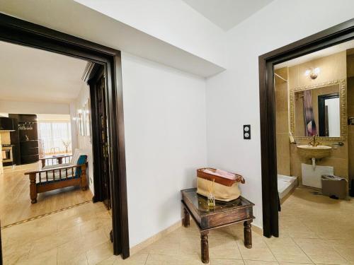 a room with a bathroom with a tub and a table at Spacious Apartment in City Centre in Iaşi