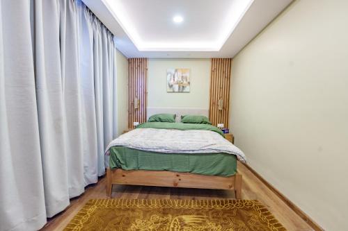 a small bedroom with a bed and curtains at Mandala Living Kathmandu in Kathmandu
