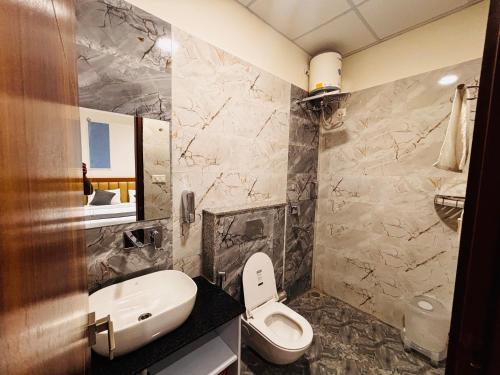 a bathroom with a white toilet and a sink at Hotel shivay palace in Rishīkesh