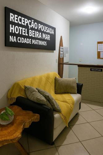a bedroom with a bed with a yellow blanket on it at Pousada Beira Mar in Matinhos
