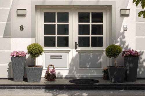a white front door of a house with potted plants at Ferienhaus Binz in Binz