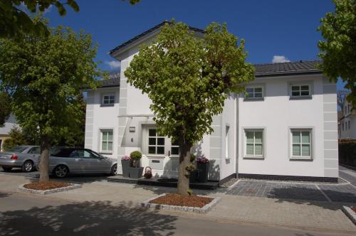 a white building with a tree in front of it at Ferienhaus Binz in Binz