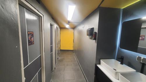 a small bathroom with two sinks and a mirror at Yellow Monkey Hostel Uluwatu in Uluwatu
