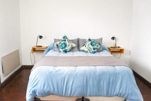 a bedroom with a large bed with blue sheets and pillows at Arístides Azul in Mendoza