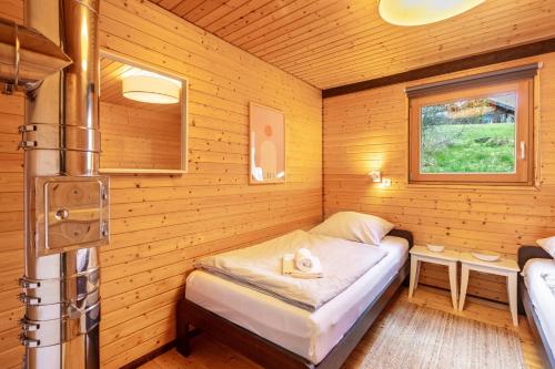 a small room with a bed in a log cabin at Chalet 22 Bernau in Bernau im Schwarzwald