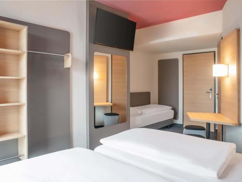 a hotel room with a bed and a desk at B&B HOTEL Stralsund in Stralsund