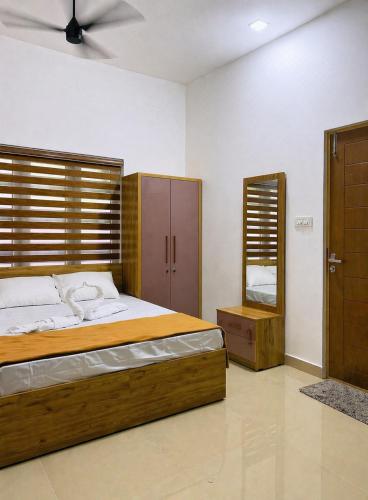 a bedroom with a large bed and a mirror at Easy Nest Kannur in Valapattanam