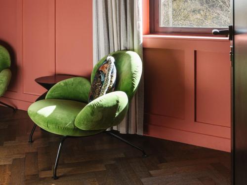 a green chair sitting next to a window at The Dean Galway in Galway