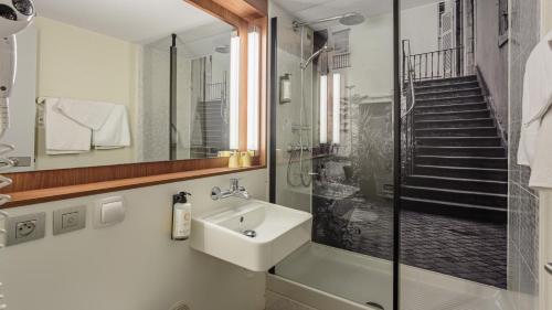 a bathroom with a sink and a shower at Campanile NATURE - Bayonne in Bayonne