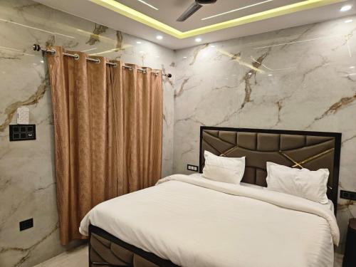 a bedroom with a large bed and a stone wall at Royal Guest House in Jammu