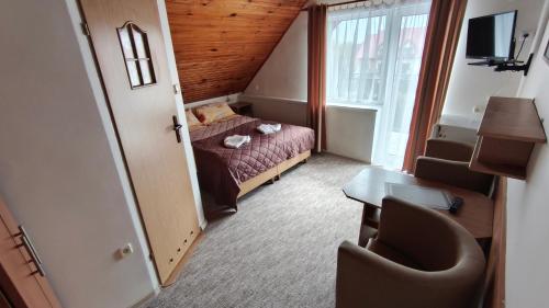 a small room with a bed and a desk and a window at DW FALA in Rewal