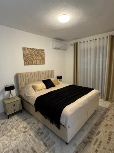 a bedroom with a large bed with a black blanket at Villa Ivanovic in Podgorica