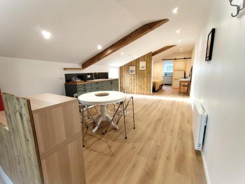 a kitchen and living room with a table in a room at Gîte Calme - Vue sur Garonne - Parking privé in Baurech